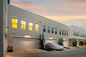 View of front of property featuring stucco siding, concrete driveway, and an attached garage