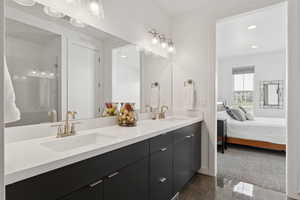 Bathroom with double vanity, ensuite bath, dark tile patterned flooring, and recessed lighting