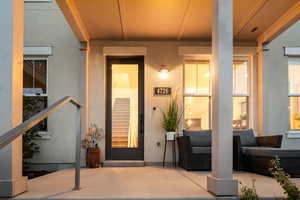 Doorway to property featuring stucco siding and a porch