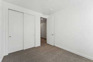 Unfurnished bedroom with carpet and a closet
