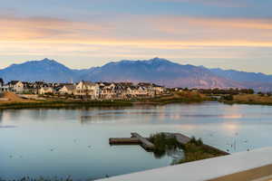 Water view with a mountainous background and a floating dock