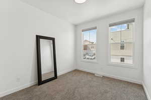 Carpeted empty room with baseboards