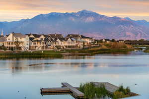 Water view with a mountainous background and a floating dock