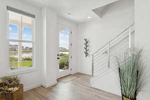 Entrance foyer featuring light wood-style flooring, recessed lighting, and a water view