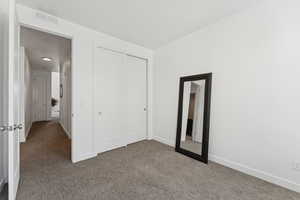 Unfurnished bedroom featuring carpet and a closet