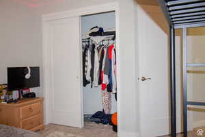 Carpeted bedroom with a closet and baseboards
