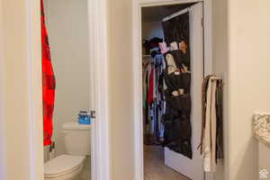 Bathroom with a walk in closet and vanity