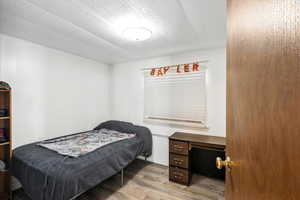Bedroom with wood finished floors and a textured ceiling