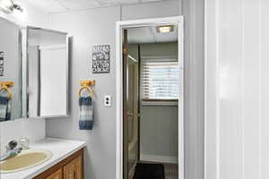 Full bath with vanity, wood finished floors, and a shower