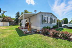 View of side of property with a storage unit
