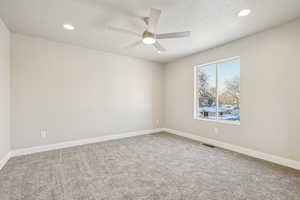 Unfurnished room with a textured ceiling, light carpet, ceiling fan, and recessed lighting