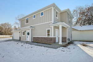 View of front facade featuring stone siding and board and batten siding