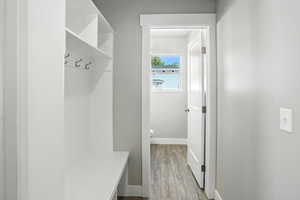 Mudroom featuring light wood-type flooring and baseboards