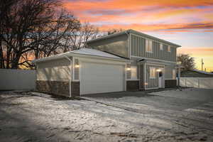 View of front of house featuring an attached garage and stone siding