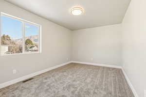 Spare room featuring light carpet and a textured ceiling