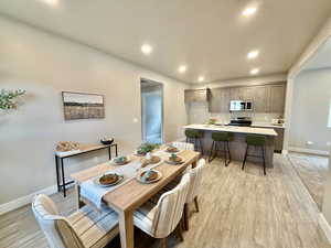 Dining area with recessed lighting and light wood finished floors