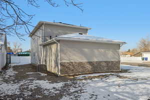 View of snow covered exterior featuring a central AC unit and stone siding