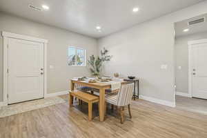 Dining area with light wood-type flooring, recessed lighting, and a textured ceiling