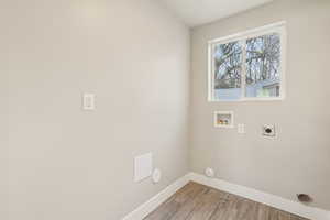 Washroom featuring wood finished floors, electric dryer hookup, and hookup for a washing machine