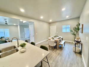 Kitchen with recessed lighting, light stone countertops, light wood-style flooring, a ceiling fan, and a textured ceiling