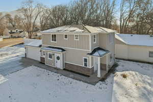 View of front of house with stone siding, board and batten siding, a garage, and a residential view