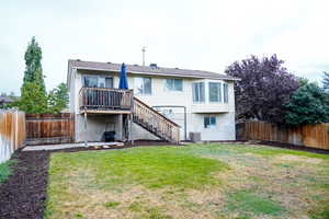 Rear view of house featuring a fenced backyard, stairs, a patio area, and a deck