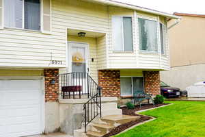 Doorway to property with brick siding and a yard