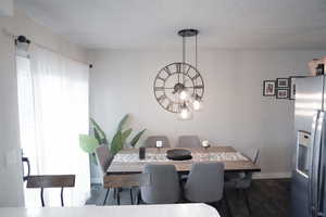 Dining room featuring dark wood-style flooring and a chandelier