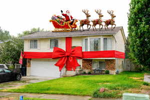 View of front of house with brick siding, concrete driveway, and a garage