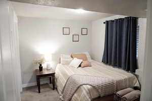 Bedroom featuring carpet and baseboards