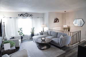 Living area with a textured ceiling, healthy amount of natural light, and wood finished floors