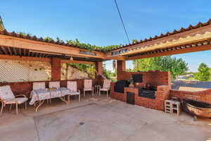 View of patio with a pergola and area for grilling