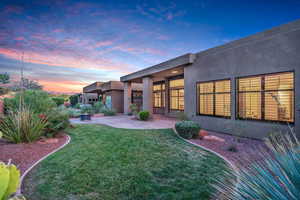 Back of house featuring stucco siding, a yard, and a patio area