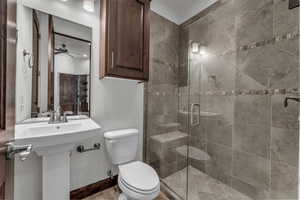 Full bath with a stall shower and ceiling fan