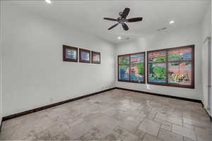 Spare room featuring stone tile flooring, recessed lighting, and a ceiling fan