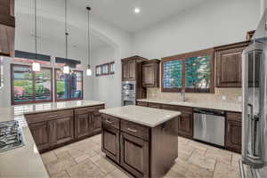 Kitchen with appliances with stainless steel finishes, stone tile floors, hanging light fixtures, healthy amount of natural light, and recessed lighting