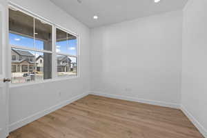 Unfurnished room with light wood finished floors, recessed lighting, and a residential view