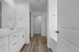 Full bath featuring vanity, dark wood-style floors, and a stall shower