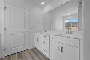 Full bathroom with light wood-style flooring, double vanity, and recessed lighting