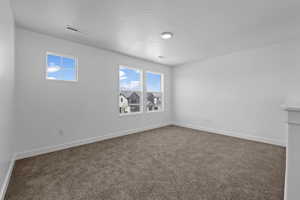 Carpeted empty room with baseboards and a textured ceiling