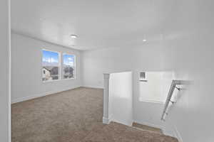 Spare room with light carpet and a textured ceiling