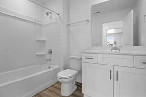 Full bath with shower / bath combination, light wood finished floors, and vanity