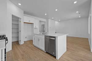 Kitchen featuring white cabinets, dishwasher, recessed lighting, light wood finished floors, and gas range