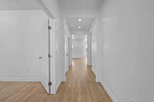 Hall featuring light wood-style floors and recessed lighting