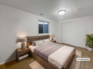 Bedroom with a closet, carpet, and a textured ceiling