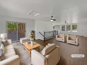 Living room featuring plenty of natural light, attic access, a ceiling fan, and wood finished floors