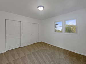 Unfurnished bedroom with carpet and a closet