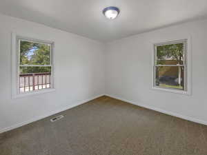 Carpeted empty room featuring baseboards