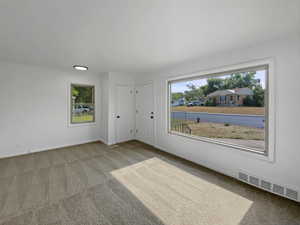 Empty room featuring light carpet and baseboards