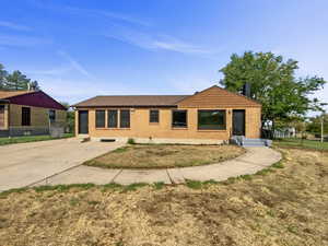 View of front of property with brick siding, roof with shingles, and concrete driveway